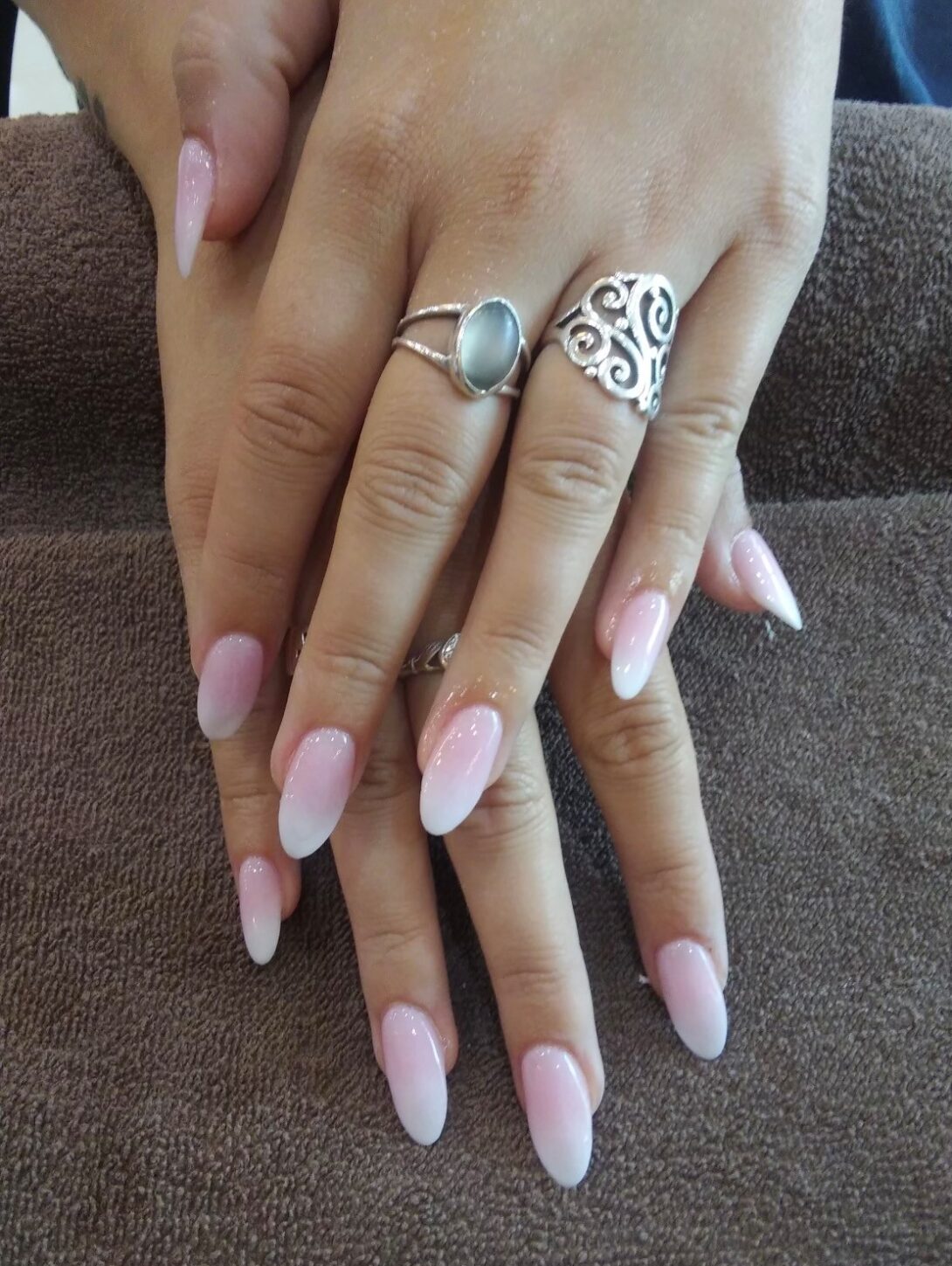 A woman 's hands with two rings on top of them.