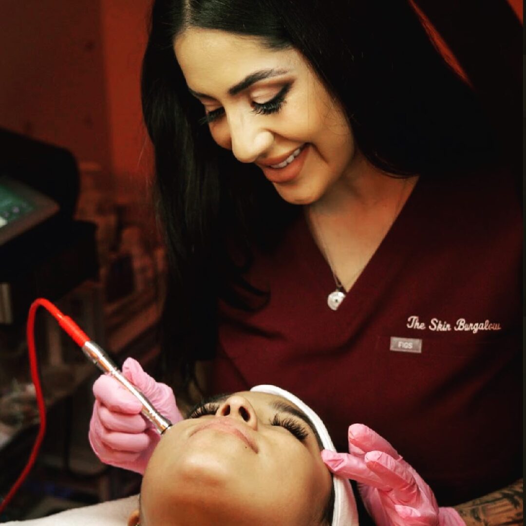 A woman is smiling while looking at the man 's face.