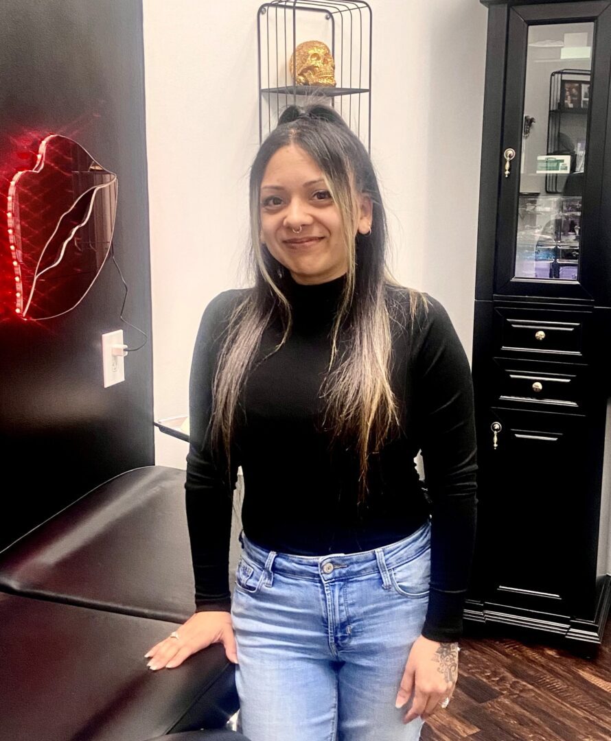 A woman standing in front of a heart on the wall.
